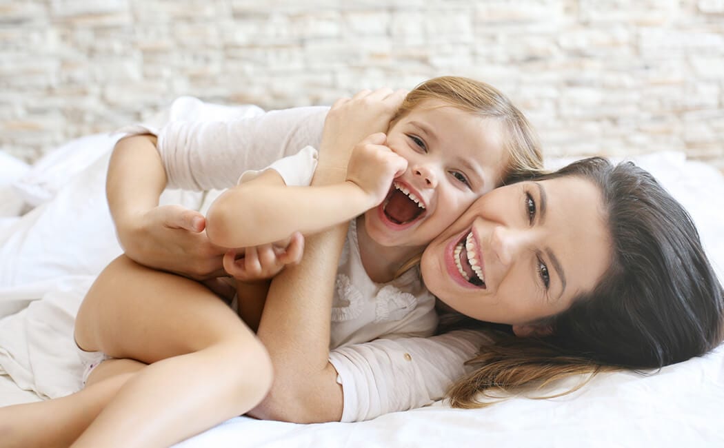 Mom-&-Daughter-Laying-In-Bed